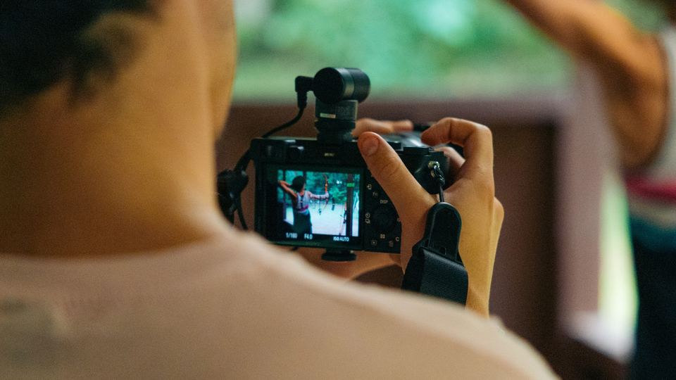 Over the shoulder of someone framing a shot on a camera screen