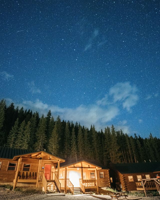 Lit cabins under a sky full of stars